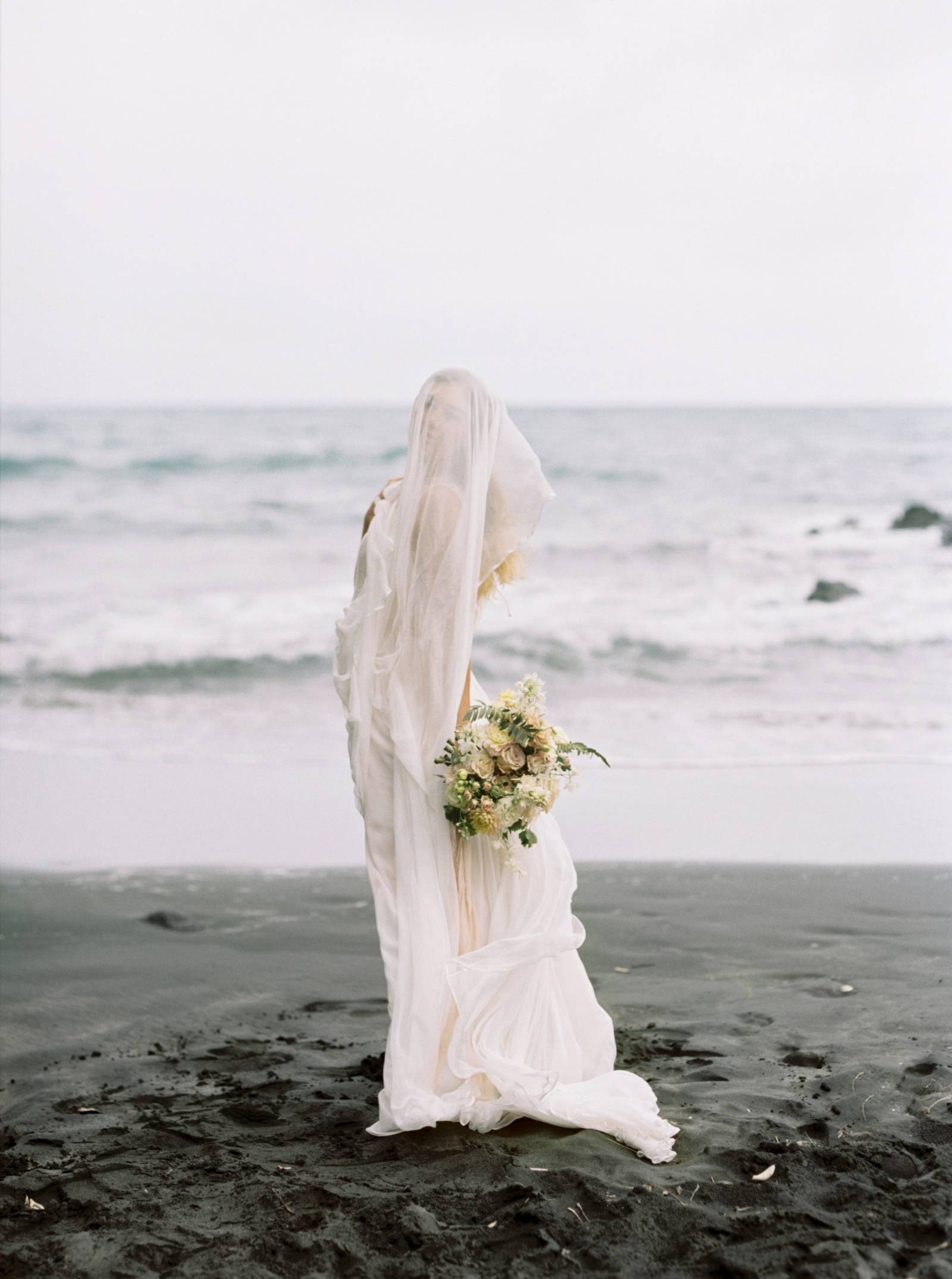 Ethereal bridal shoot on a black sand beach in New Zealand