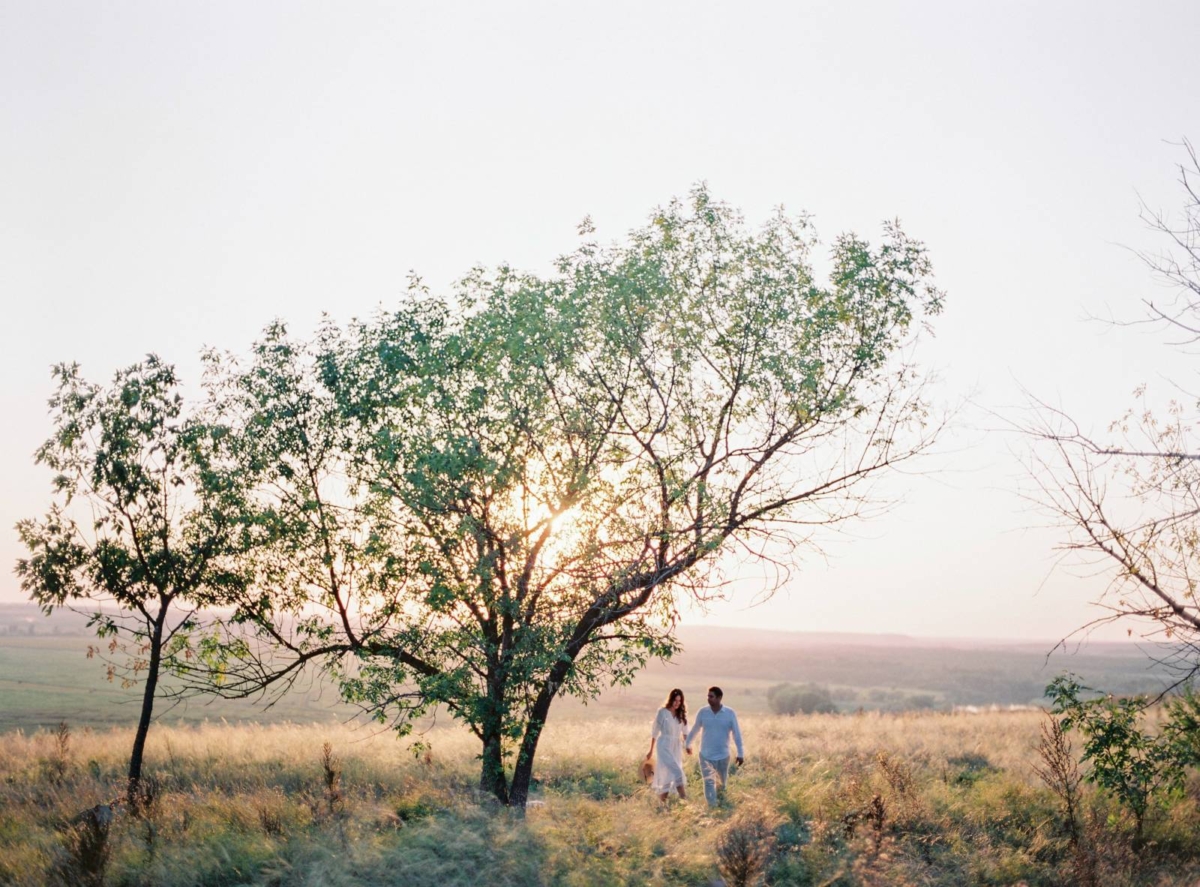 A Russian love shoot in grassy fields bathed in golden sunlight